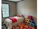 Comfortable bedroom with bright rug and single bed at 9494 Se 144Th Pl, Summerfield, FL 34491