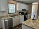 Bright kitchen featuring white cabinets, stainless steel appliances, and granite countertops at 9494 Se 144Th Pl, Summerfield, FL 34491
