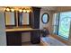 Bathroom featuring double vanity, makeup counter, bathtub, and stained glass window at 12430 Blue Heron Way, Leesburg, FL 34788