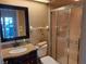 Bathroom featuring granite vanity, framed mirror and a step-in shower with glass doors at 12430 Blue Heron Way, Leesburg, FL 34788