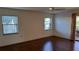 Bedroom with hardwood floors, two windows and sliding doors to the outside at 12430 Blue Heron Way, Leesburg, FL 34788