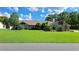 Charming single-story home with a well-maintained lawn and mature trees under a bright blue sky at 12430 Blue Heron Way, Leesburg, FL 34788