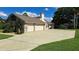 Spacious three-car garage with a large driveway and well-manicured lawn at 12430 Blue Heron Way, Leesburg, FL 34788