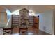 Living room with stone fireplace and built-in shelving with backyard view at 12430 Blue Heron Way, Leesburg, FL 34788