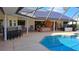 Outdoor pool with a bar, table, chairs, and a lounge area under a screened enclosure at 12430 Blue Heron Way, Leesburg, FL 34788