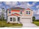 Two-story home featuring a two-car garage, neutral paint, and a well-manicured lawn at 1617 Sage Ave, Haines City, FL 33844