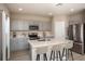 Modern kitchen features gray cabinetry, stainless steel appliances, and a large island with bar seating at 1617 Sage Ave, Haines City, FL 33844