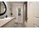 Bathroom features a single sink vanity, toilet, and tiled shower/tub combo next to door to outside at 3610 Amber Ln, Lakeland, FL 33812