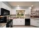 Bright kitchen with white cabinetry, black appliances, granite countertops, and a stainless sink at 3610 Amber Ln, Lakeland, FL 33812