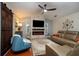 Inviting living room featuring a cozy fireplace, modern ceiling fan, and stylish decor at 3610 Amber Ln, Lakeland, FL 33812