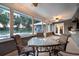 Enclosed sunroom with tile flooring, dining set, and windows overlooking the pool and backyard at 3610 Amber Ln, Lakeland, FL 33812