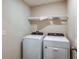 A laundry room equipped with a washer and dryer and a wire shelf for storage solutions at 4035 Gardenia Ave, Lake Hamilton, FL 33851