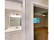 Bathroom with vanity and mirror, with view to secondary bedroom with ceiling fan at 6255 Christina Ct, Orlando, FL 32810