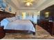 Bright primary bedroom with a king-size bed, television, wood floors and a serene atmosphere at 205 Golf Aire Blvd, Haines City, FL 33844