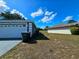 Single Gathering home featuring a two-car garage on a partly sunny day at 205 Golf Aire Blvd, Haines City, FL 33844