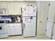 Compact kitchen equipped with white appliances and cabinets, maximizing space at 205 Golf Aire Blvd, Haines City, FL 33844