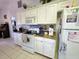 Well-lit kitchen featuring white cabinets, modern appliances, and tile flooring at 205 Golf Aire Blvd, Haines City, FL 33844