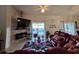 Living room with stone fireplace, large tv, leather sectional, and view of pool at 205 Golf Aire Blvd, Haines City, FL 33844