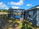 Home featuring screened-in pool, lanai and yard on sunny day at 205 Golf Aire Blvd, Haines City, FL 33844