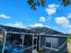 View of pool and lanai, plus a bedroom with double windows at 205 Golf Aire Blvd, Haines City, FL 33844