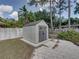 Backyard view of a gray shed with a gray roof and door, situated on a concrete pad at 2271 Crystal Grove Ln, Lakeland, FL 33801