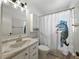Bathroom featuring a shower with a whimsical dinosaur shower curtain, a vanity, and ample lighting at 2271 Crystal Grove Ln, Lakeland, FL 33801