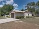 Spacious home featuring an attached garage, a well-manicured lawn, and mature trees at 2271 Crystal Grove Ln, Lakeland, FL 33801