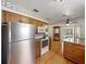 Kitchen features stainless steel appliances, wood cabinets, granite countertops, breakfast bar, and hardwood floors at 2271 Crystal Grove Ln, Lakeland, FL 33801
