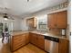 The kitchen features wood cabinets, granite countertops, a stainless steel dishwasher, and hardwood floors at 2271 Crystal Grove Ln, Lakeland, FL 33801