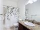 Bathroom with granite countertop, floral shower curtain, and a well-lit mirror at 2806 Spinning Silk Ct, Kissimmee, FL 34747