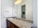 This bathroom features a granite vanity and a large mirror, and is brightly illuminated at 2806 Spinning Silk Ct, Kissimmee, FL 34747