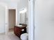 Bathroom featuring granite vanity, framed mirror, shower with glass doors, and tile floor at 2806 Spinning Silk Ct, Kissimmee, FL 34747