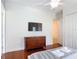 Bright bedroom with hardwood floors, ceiling fan, a mounted TV, and a dresser at 2806 Spinning Silk Ct, Kissimmee, FL 34747
