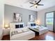 Bright bedroom showcasing two beds, modern art, a ceiling fan, and a window at 2806 Spinning Silk Ct, Kissimmee, FL 34747
