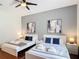 Charming bedroom featuring two beds, gray accent wall, modern art, and wood floors at 2806 Spinning Silk Ct, Kissimmee, FL 34747