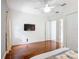 A bright bedroom with hardwood floors and a large tv, with an open doorway in the back at 2806 Spinning Silk Ct, Kissimmee, FL 34747