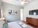 Bedroom showcasing hardwood floors, contemporary art, and a mounted TV above a dresser at 2806 Spinning Silk Ct, Kissimmee, FL 34747