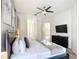 Bright primary bedroom featuring a ceiling fan, wall-mounted TV, and private bathroom access at 2806 Spinning Silk Ct, Kissimmee, FL 34747