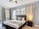 This primary bedroom features a ceiling fan, stylish decor, and natural light from a window and glass door at 2806 Spinning Silk Ct, Kissimmee, FL 34747