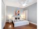 Bright bedroom featuring a white ceiling fan, modern art, hardwood floors, and a plush white bed at 2806 Spinning Silk Ct, Kissimmee, FL 34747