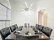 Elegant dining room with modern light fixture, large window, and seating for ten at 2806 Spinning Silk Ct, Kissimmee, FL 34747