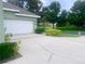 Long driveway leading to a two-car garage, surrounded by lush landscaping and mature trees at 2806 Spinning Silk Ct, Kissimmee, FL 34747