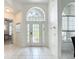 Bright foyer with tile flooring, arched windows, and decorative glass front door at 2806 Spinning Silk Ct, Kissimmee, FL 34747