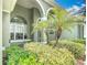 Inviting front entrance featuring arched doorways, large windows, and lush landscaping at 2806 Spinning Silk Ct, Kissimmee, FL 34747