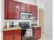 A kitchen with wooden cabinets, granite countertops, and black appliances at 2806 Spinning Silk Ct, Kissimmee, FL 34747