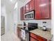 A kitchen with wooden cabinets, granite countertops, and black appliances at 2806 Spinning Silk Ct, Kissimmee, FL 34747