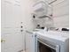 Laundry room featuring a modern washer and dryer, shelving, and convenient access to the backyard at 2806 Spinning Silk Ct, Kissimmee, FL 34747
