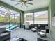 Spacious covered patio with ceiling fan, seating, and a grill for outdoor enjoyment by the screened pool at 2806 Spinning Silk Ct, Kissimmee, FL 34747