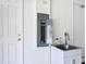A utility room featuring a wash basin next to a wall-mounted circuit breaker panel and two white doors at 2806 Spinning Silk Ct, Kissimmee, FL 34747