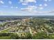 Expansive aerial view showing neighborhood with lush trees, a lake, and inviting community pool at 519 Market W Sq, Lakeland, FL 33813